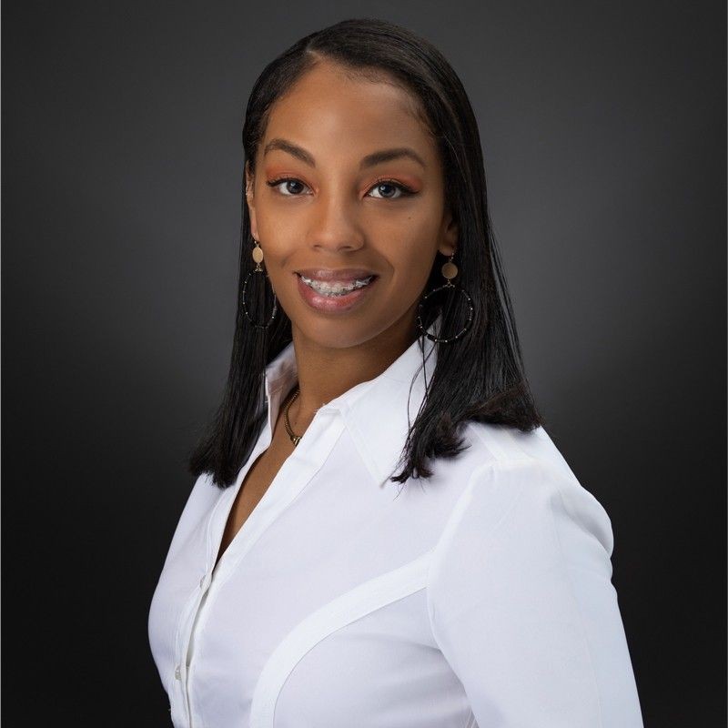 The image depicts a headshot photograph of Kyiia Rollag, a young Black female professional in a white button-up blouse.